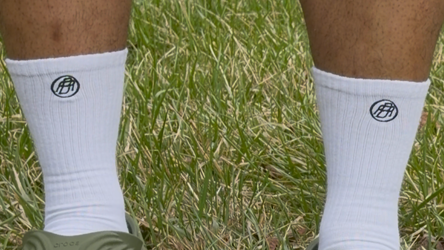 White socks with a logo worn on grass